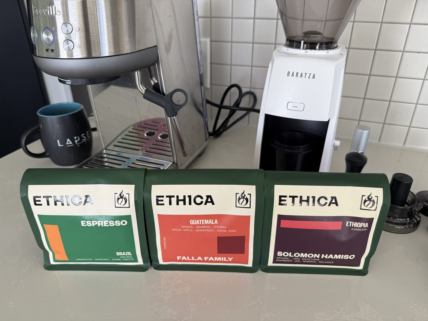 Three Ethica coffee bags lined up on a counter