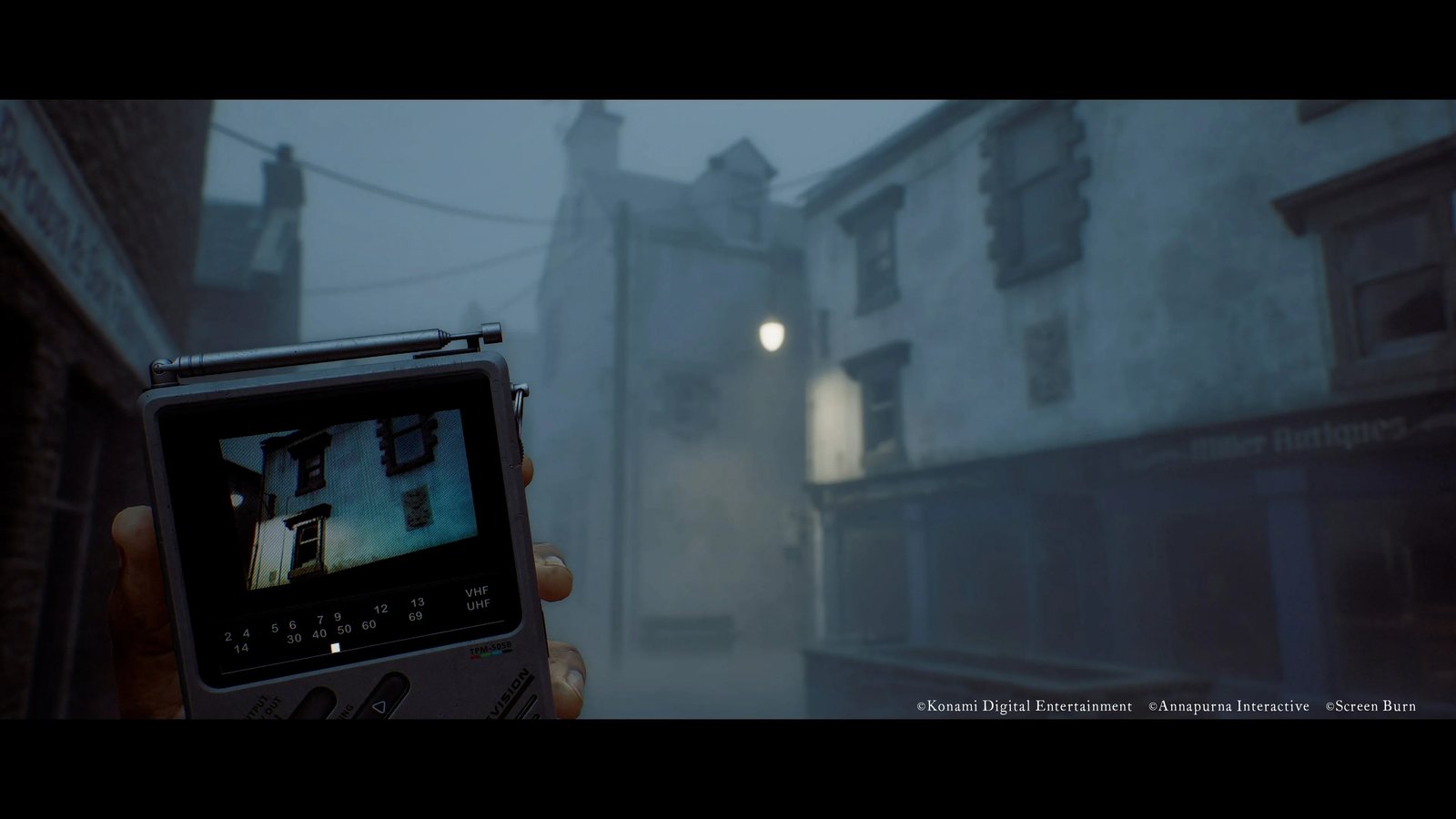 A handheld CRTV showing a building on a foggy street in Silent Hill: Townfall